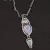 "Blue Moon Magic" Necklace. There are three opals in a line down. The top one is a small horizontal oval. The next one is a larger, vertical opal. The bottom one is a small triangle. Each one has silver ball detail surrounding it, as well as hammered silver.