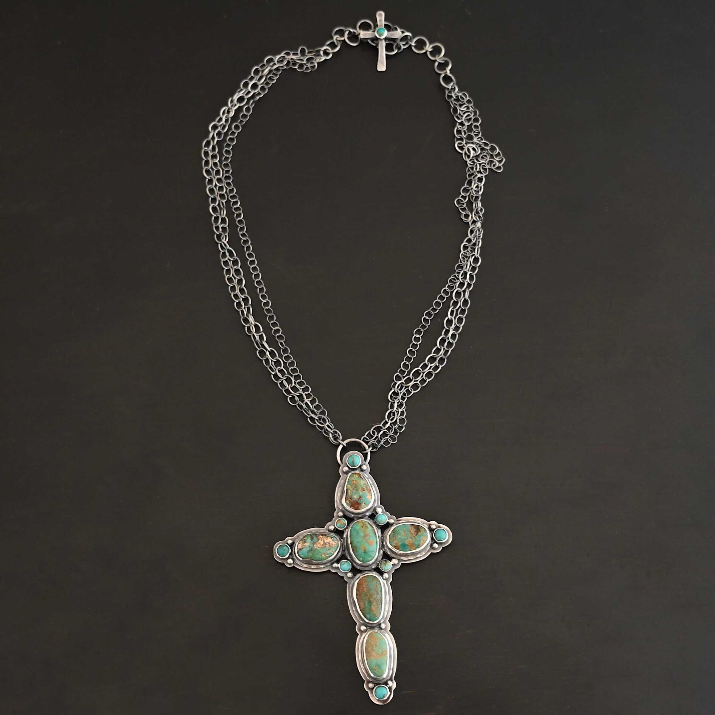 Firm In Faith Necklace "Firm In Faith" Necklace. Necklace is a large cross shape with six oval turquoise creating the cross shape and eight small circular turquoise around the rest of the pendant. Chain is multiple strands that meet at the back. Necklace has a small silver cross with a turquoise in the center of it for the clasp.