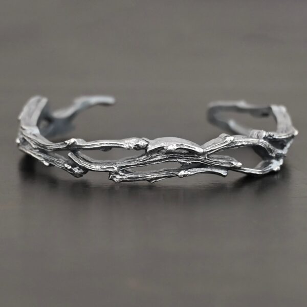 "Forests And Groves" Cuff. The cuff is casted sterling silver branches from a tree that are curved.