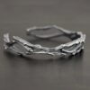 "Forests And Groves" Cuff. The cuff is casted sterling silver branches from a tree that are curved.