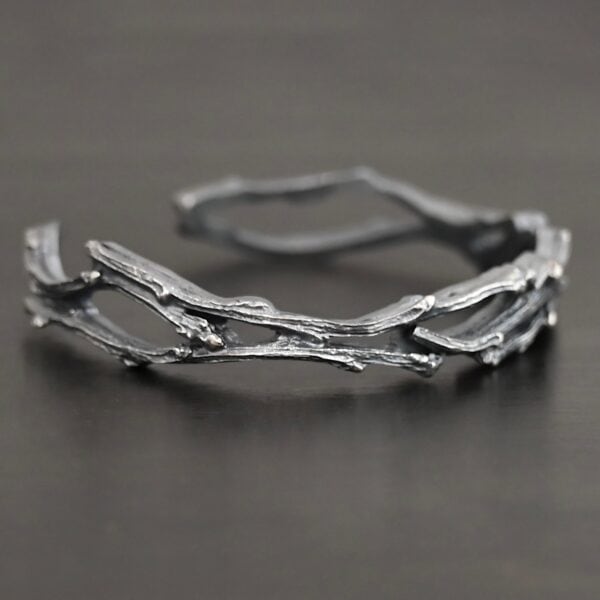 "Forests And Groves" Cuff. The cuff is casted sterling silver branches from a tree that are curved.