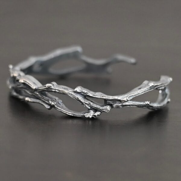 "Forests And Groves" Cuff. The cuff is casted sterling silver branches from a tree that are curved.