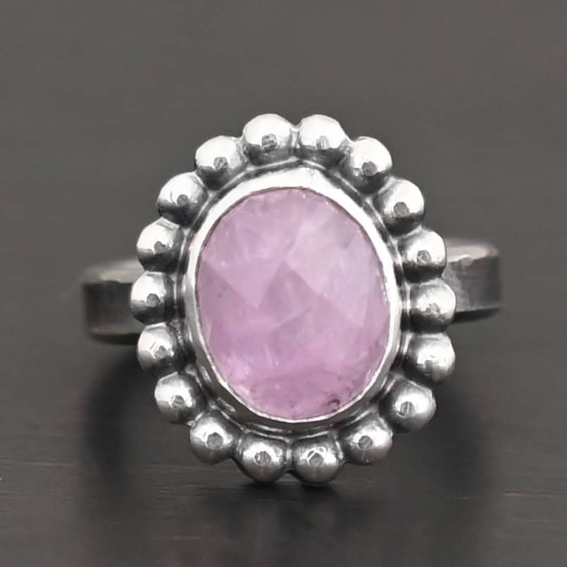 "Pink Glow" Ring. Sterling Silver & Kunzite. There is an oval, vertical kunzite in the center with balls of silver circling all the way around it. Ring band is smooth & lightly oxidized.