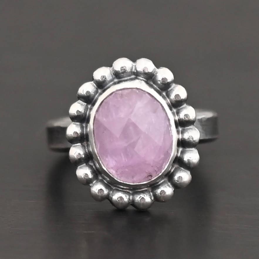 "Pink Glow" Ring. Sterling Silver & Kunzite. There is an oval, vertical kunzite in the center with balls of silver circling all the way around it. Ring band is smooth & lightly oxidized.