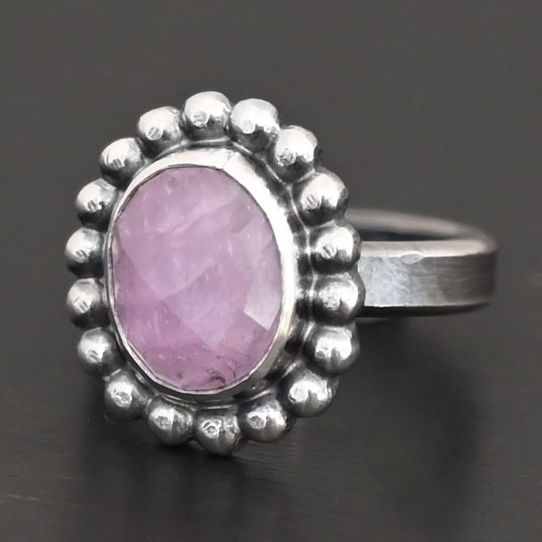 "Pink Glow" Ring. Sterling Silver & Kunzite. There is an oval, vertical kunzite in the center with balls of silver circling all the way around it. Ring band is smooth & lightly oxidized.