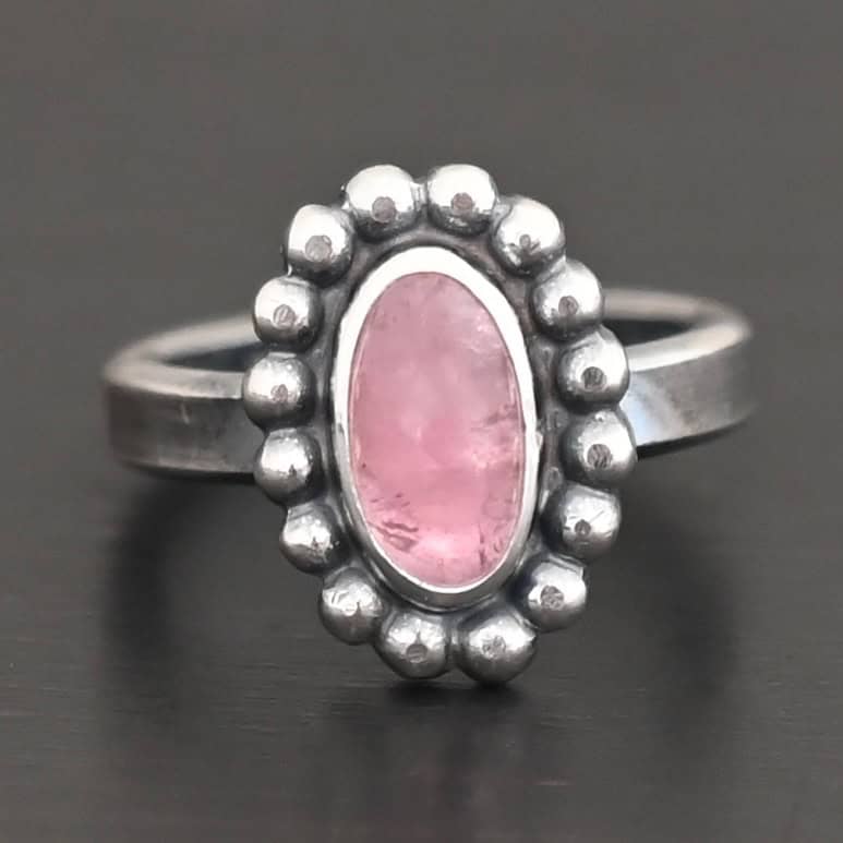 Rosalyn Ring "Rosalyn" Ring. Sterling Silver & Tourmaline. There is an oval, vertical tourmaline in the center with balls of silver circling all the way around it. Ring band is smooth & lightly oxidized.