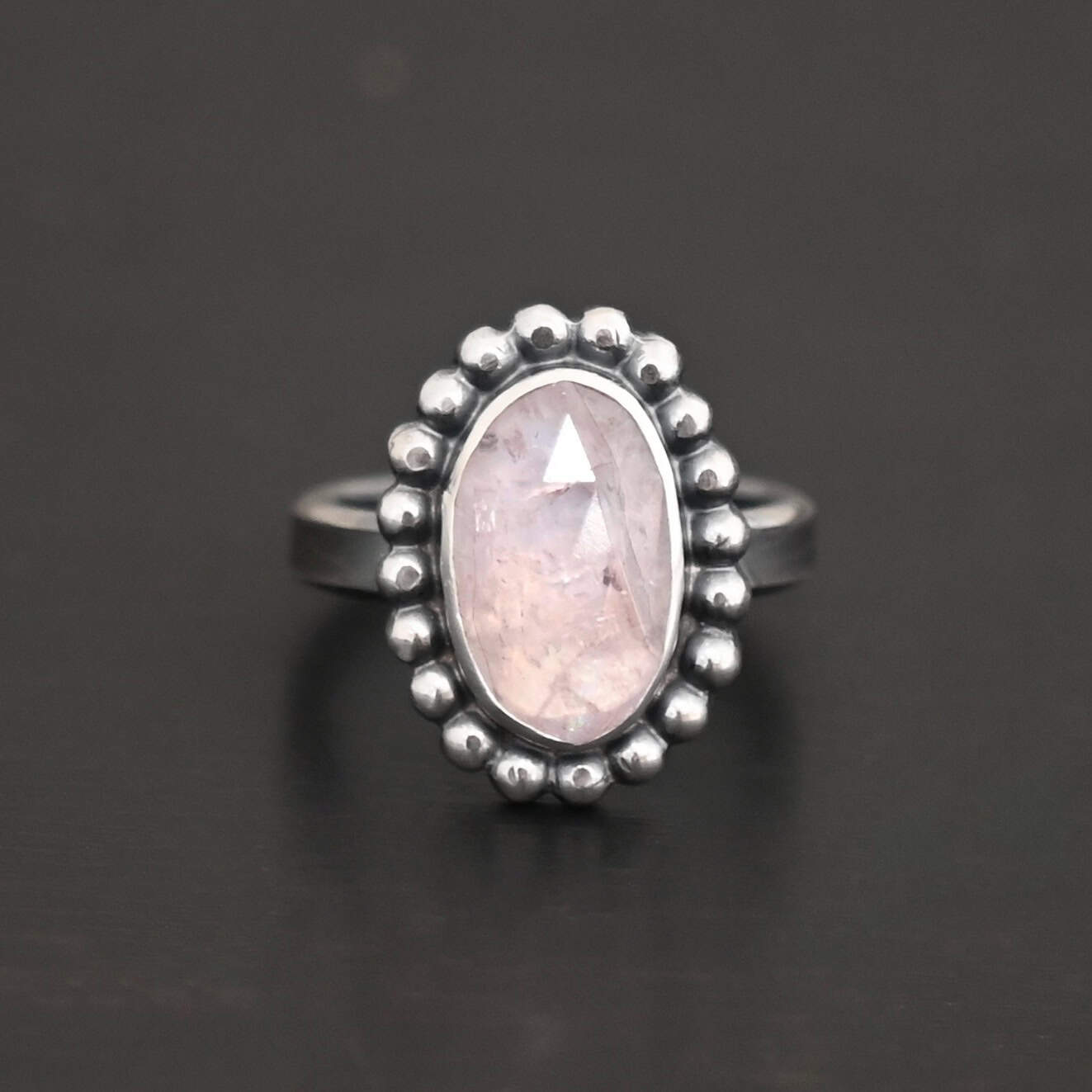 Calliope Ring "Calliope" Ring. Sterling Silver & Morganite. There is an oval, vertical morganite in the center with balls of silver circling all the way around it. Ring band is smooth & lightly oxidized.