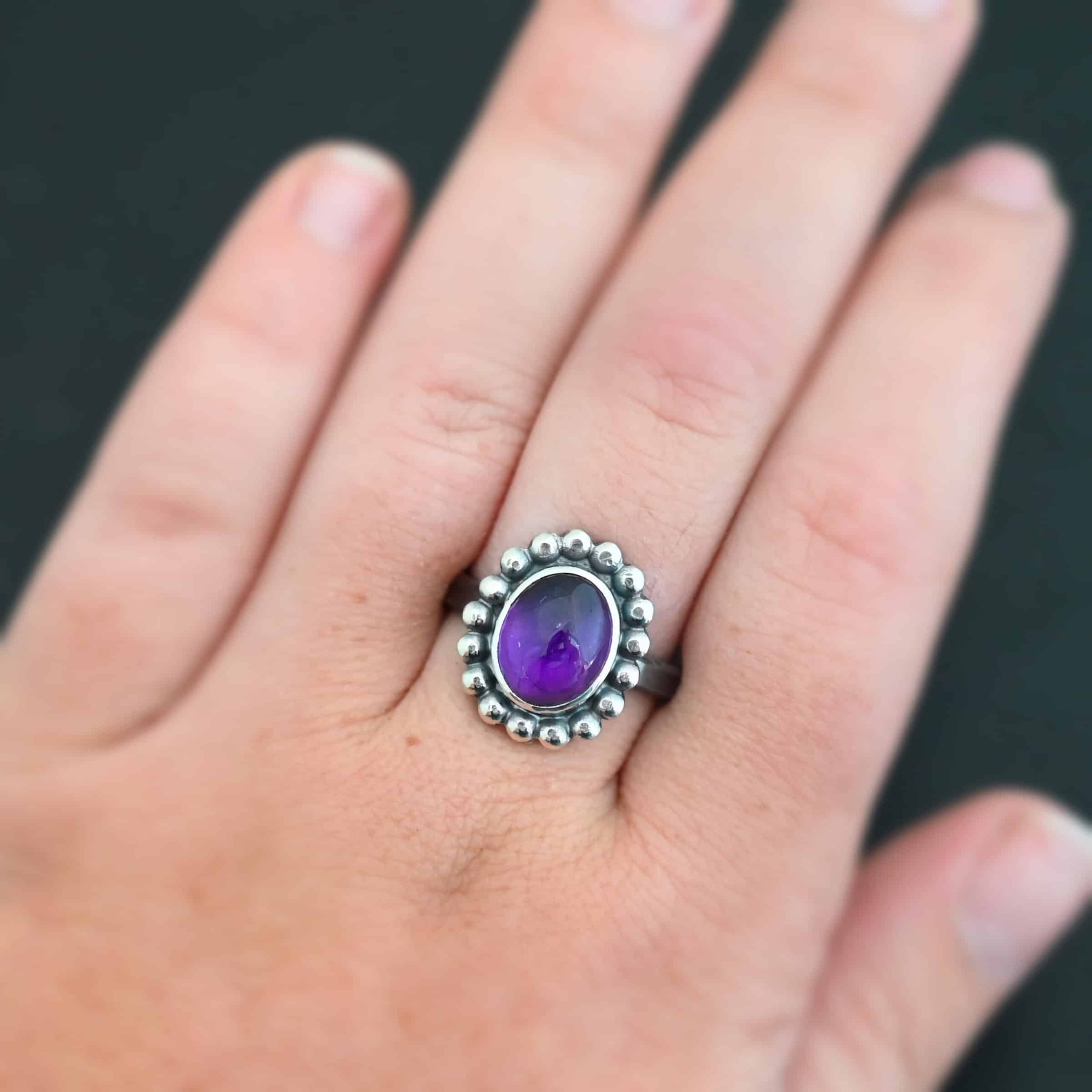 Viola Ring "Viola" Ring. Sterling Silver & Amethyst. There is an oval, vertical amethyst in the center with balls of silver circling all the way around it. Ring band is smooth & lightly oxidized.