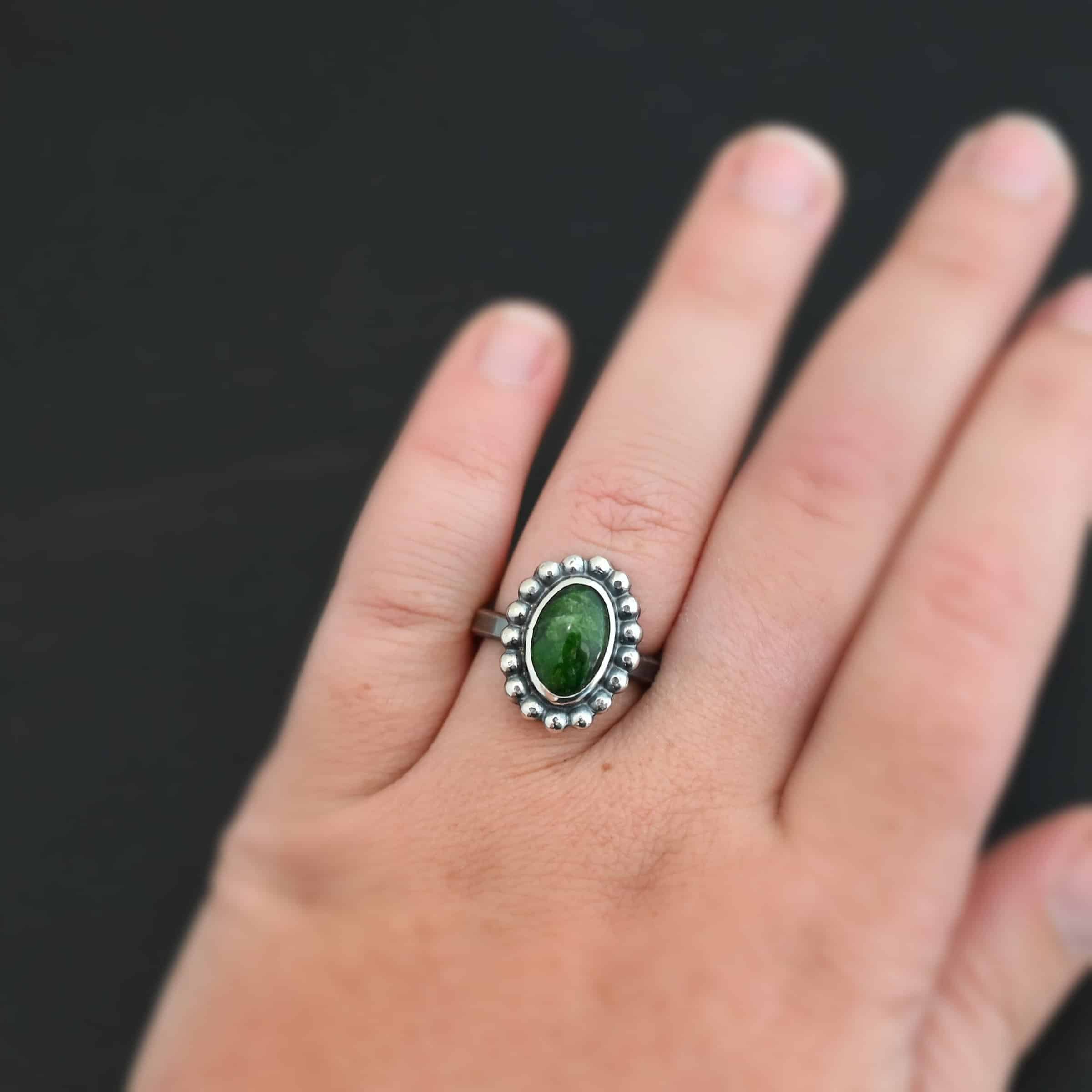 "New Leaf" Ring. Sterling Silver & Chrome Diopside. There is an oval, vertical chrome diopside in the center with balls of silver circling all the way around it. Ring band is smooth & lightly oxidized.