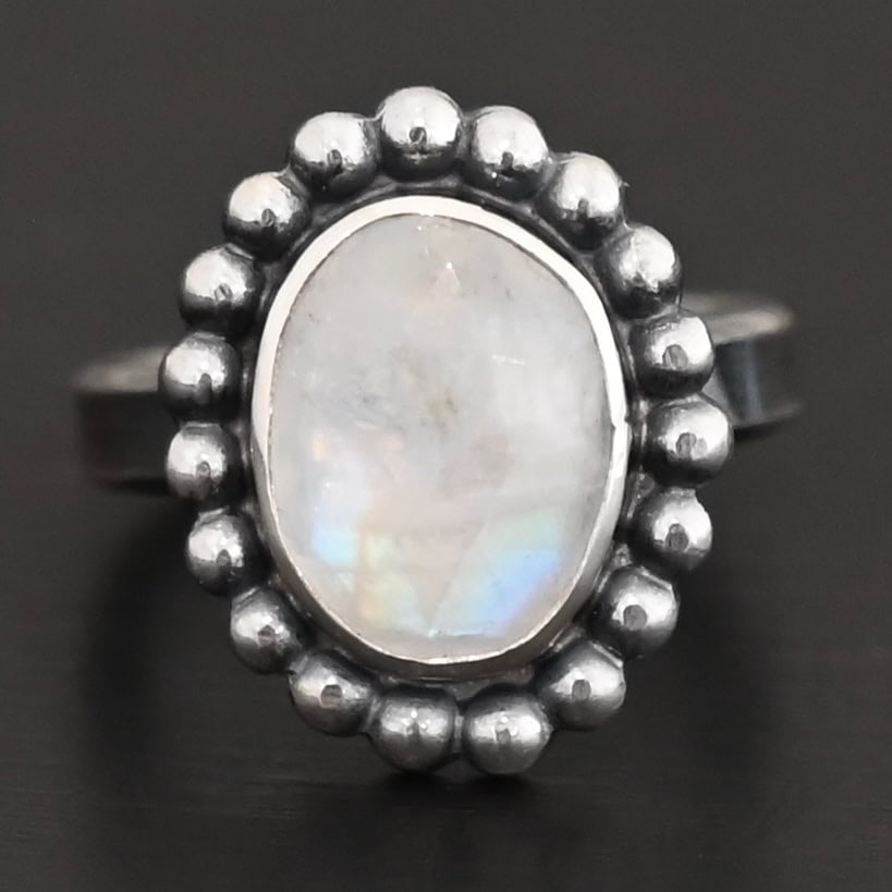 Shining Dreams Ring "Shining Dreams" Ring. Sterling Silver & Moonstone. There is an oval, vertical moonstone in the center with balls of silver circling all the way around it. Ring band is smooth & lightly oxidized.