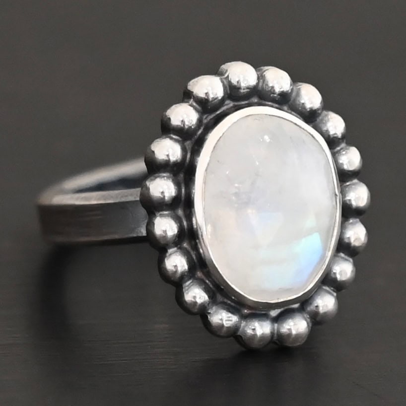 Shining Dreams Ring "Shining Dreams" Ring. Sterling Silver & Moonstone. There is an oval, vertical moonstone in the center with balls of silver circling all the way around it. Ring band is smooth & lightly oxidized.