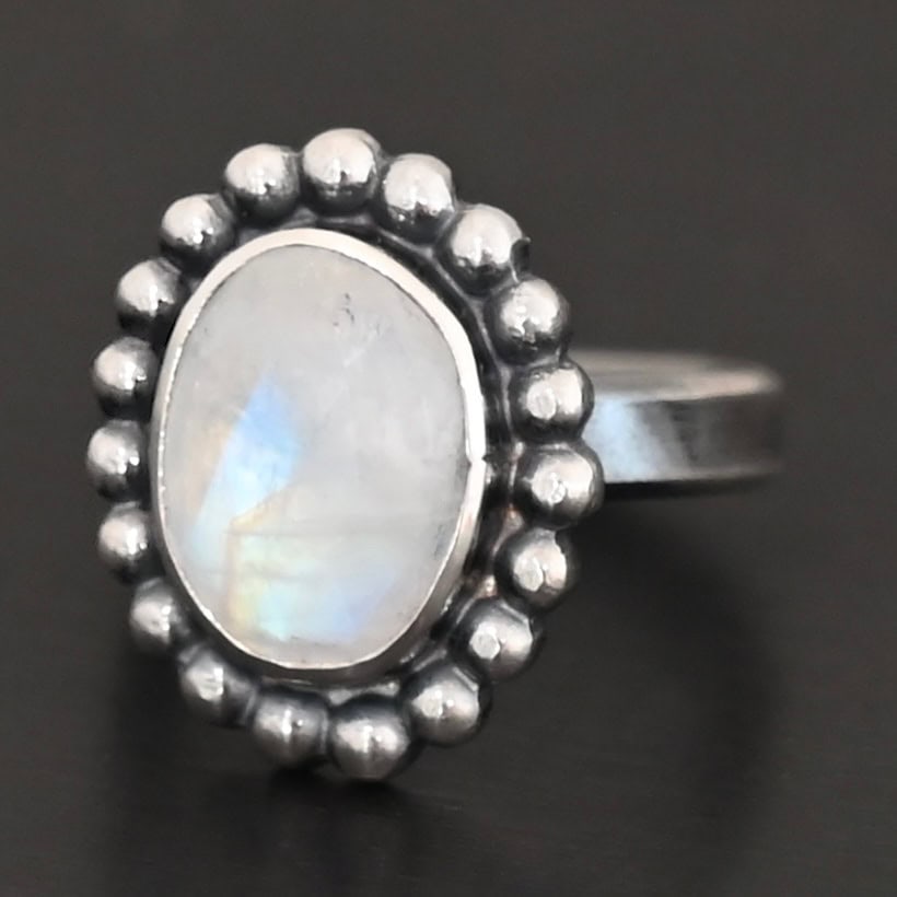 Shining Dreams Ring "Shining Dreams" Ring. Sterling Silver & Moonstone. There is an oval, vertical moonstone in the center with balls of silver circling all the way around it. Ring band is smooth & lightly oxidized.