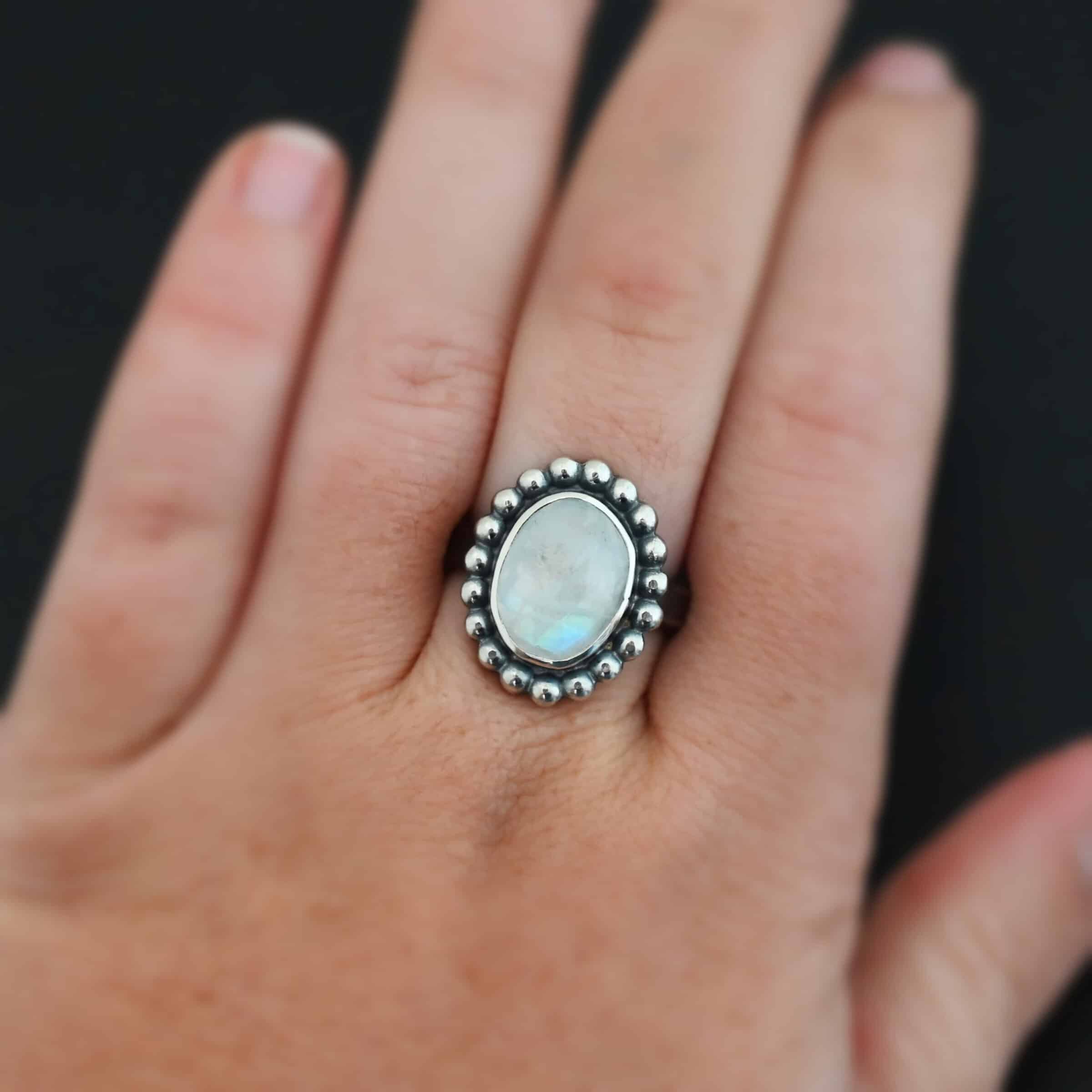 Shining Dreams Ring "Shining Dreams" Ring. Sterling Silver & Moonstone. There is an oval, vertical moonstone in the center with balls of silver circling all the way around it. Ring band is smooth & lightly oxidized.