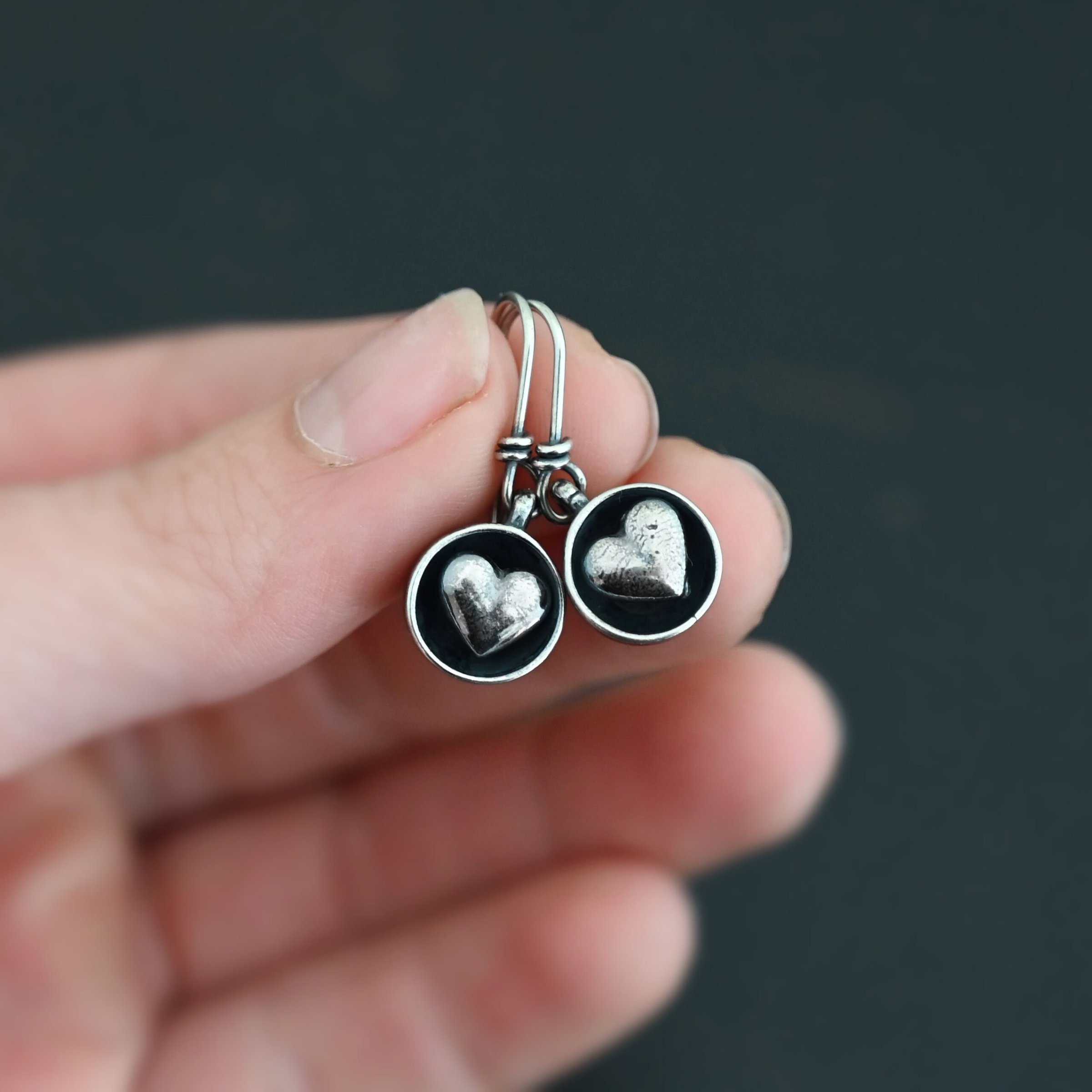 "Cups Of Love" Earrings. Earrings have sterling silver french hook ear wires. Hanging at the bottom of each is a small silver "cup" with a silver heart in the center of it.