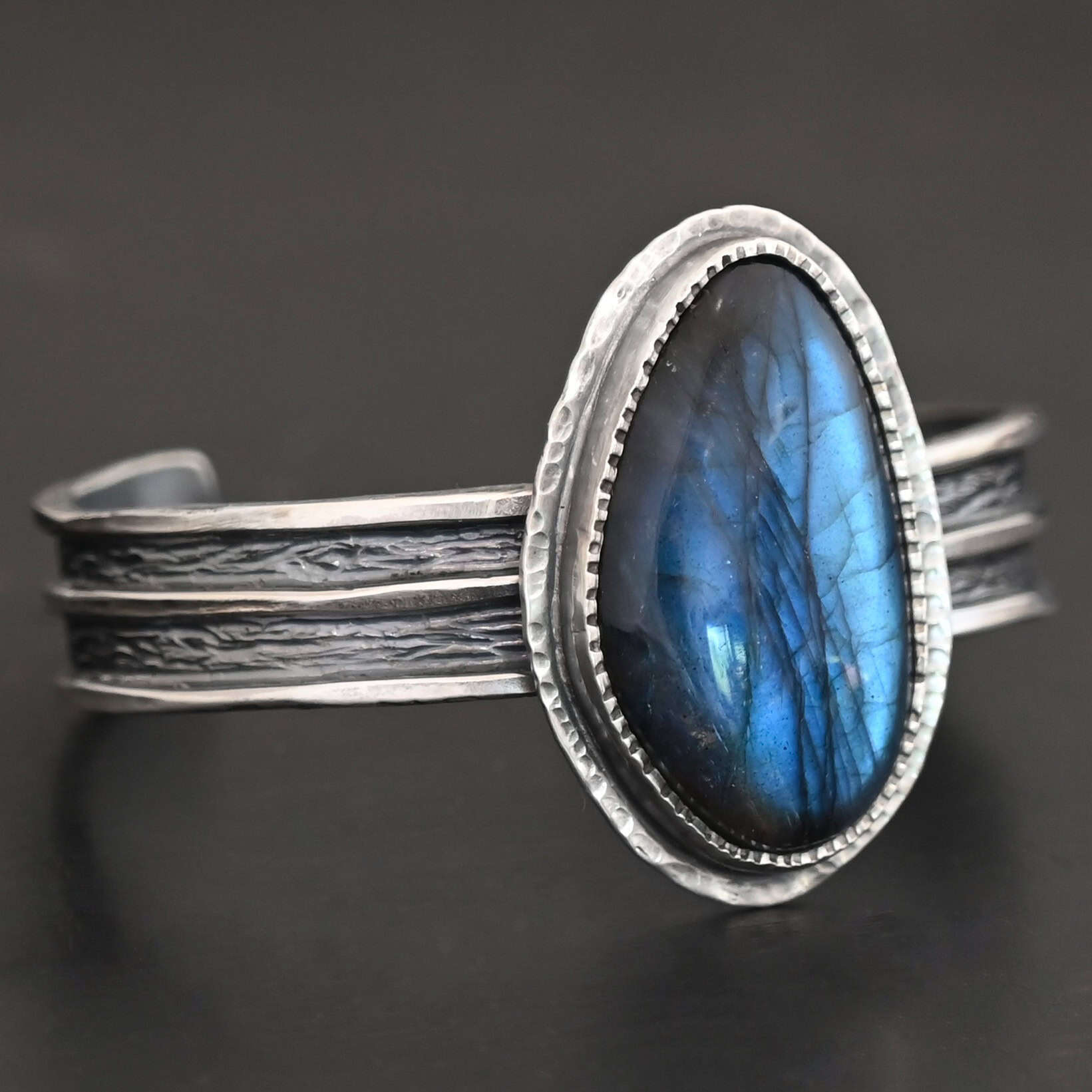 Deep Ocean Cuff "Deep Ocean" Cuff. Sterling Silver & Labradorite. There is an oval, vertical labradorite in the center with two hammered layers of sterling silver around it. The cuff has a thicker band, with a shiny line of silver down the middle and in between the shiny line is oxidized.