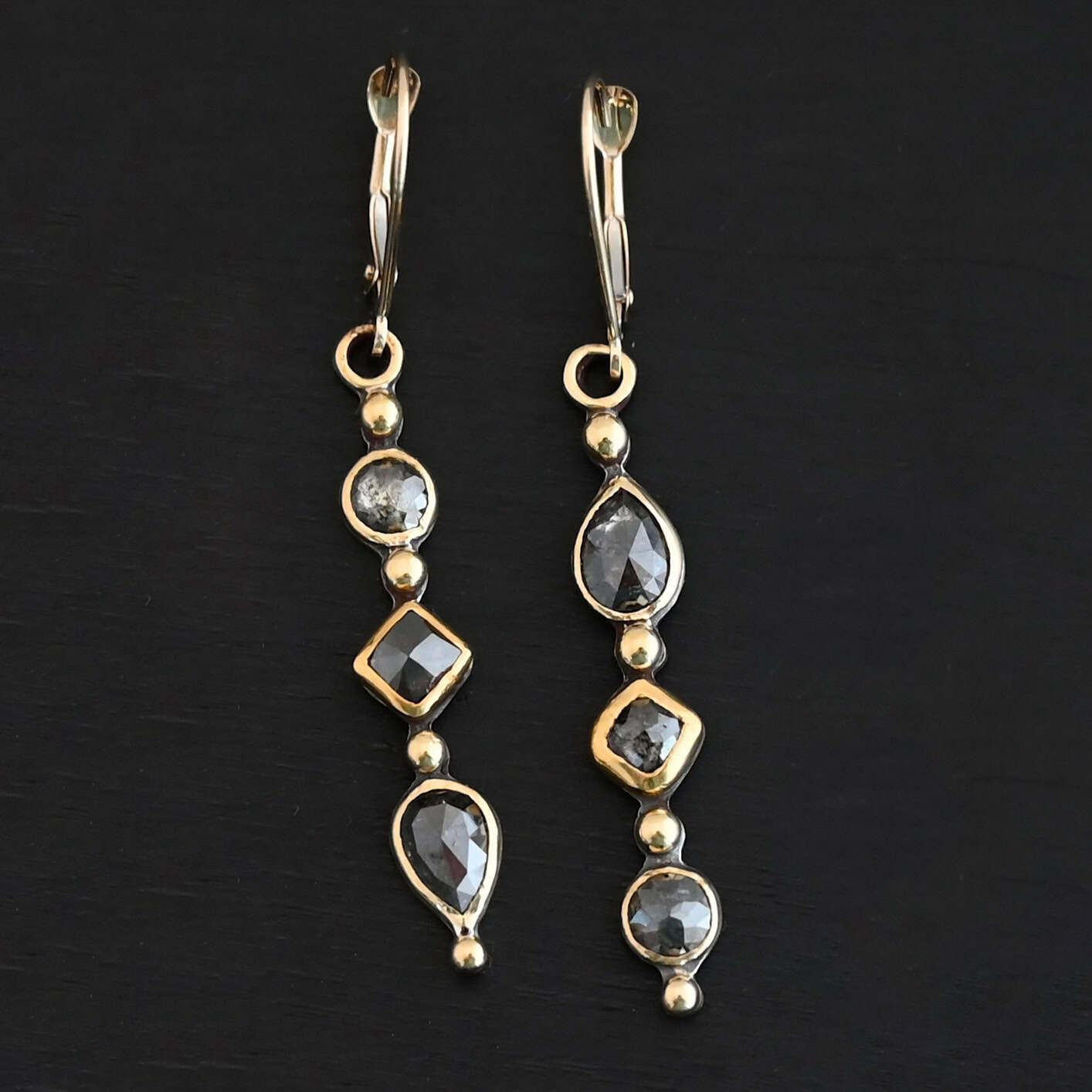 Zia Earrings "Zia" Earrings. Gold and Diamonds. Each earring has three brown diamonds. Each earring has four balls of gold separating the diamonds and above and below them. Earrings have gold ear wires.