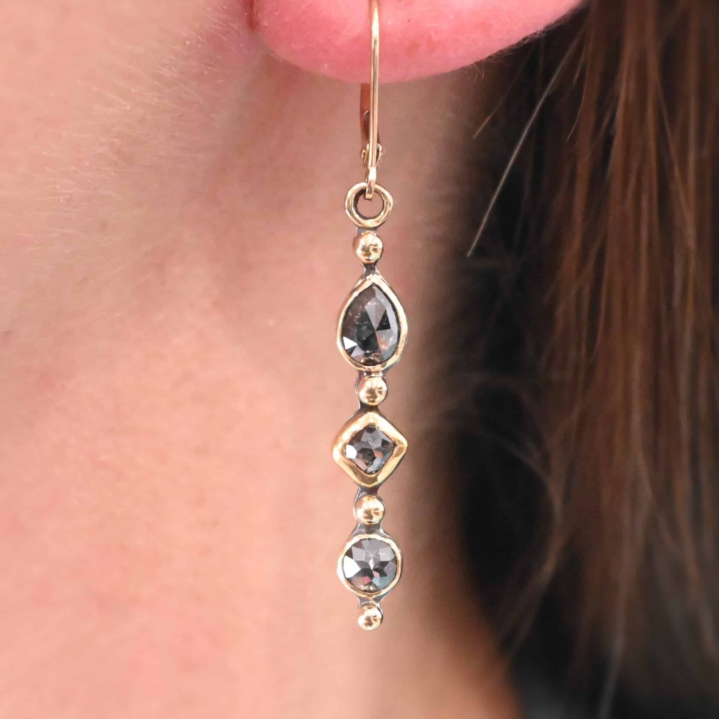 Zia Earrings "Zia" Earrings. Gold and Diamonds. Each earring has three brown diamonds. Each earring has four balls of gold separating the diamonds and above and below them. Earrings have gold ear wires.